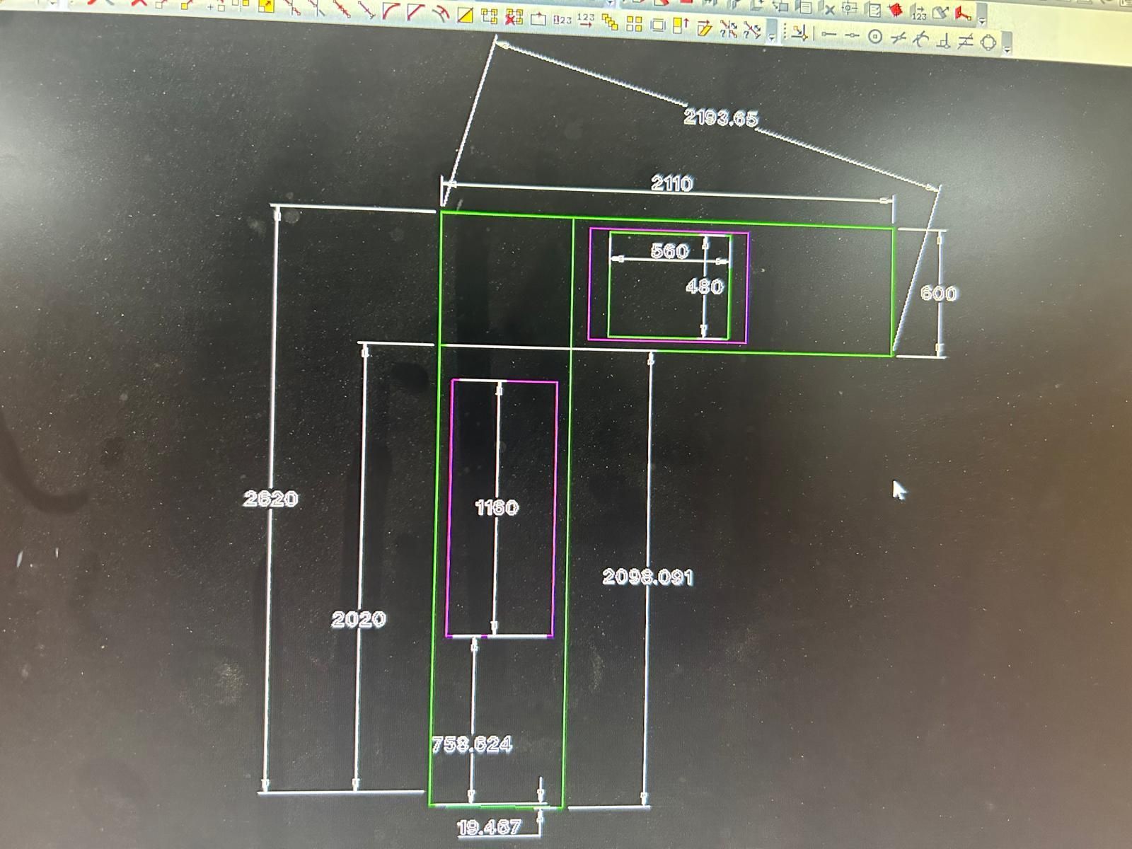 Schizzo tecnico disegnato a mano su una lavagna con linee di misurazione e dimensioni bianche e verdi.