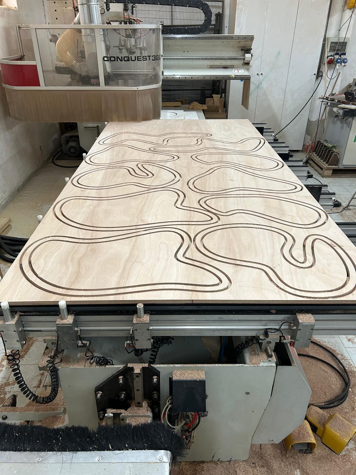 Fresatrice CNC per il taglio di pannelli di legno curvi in un'officina