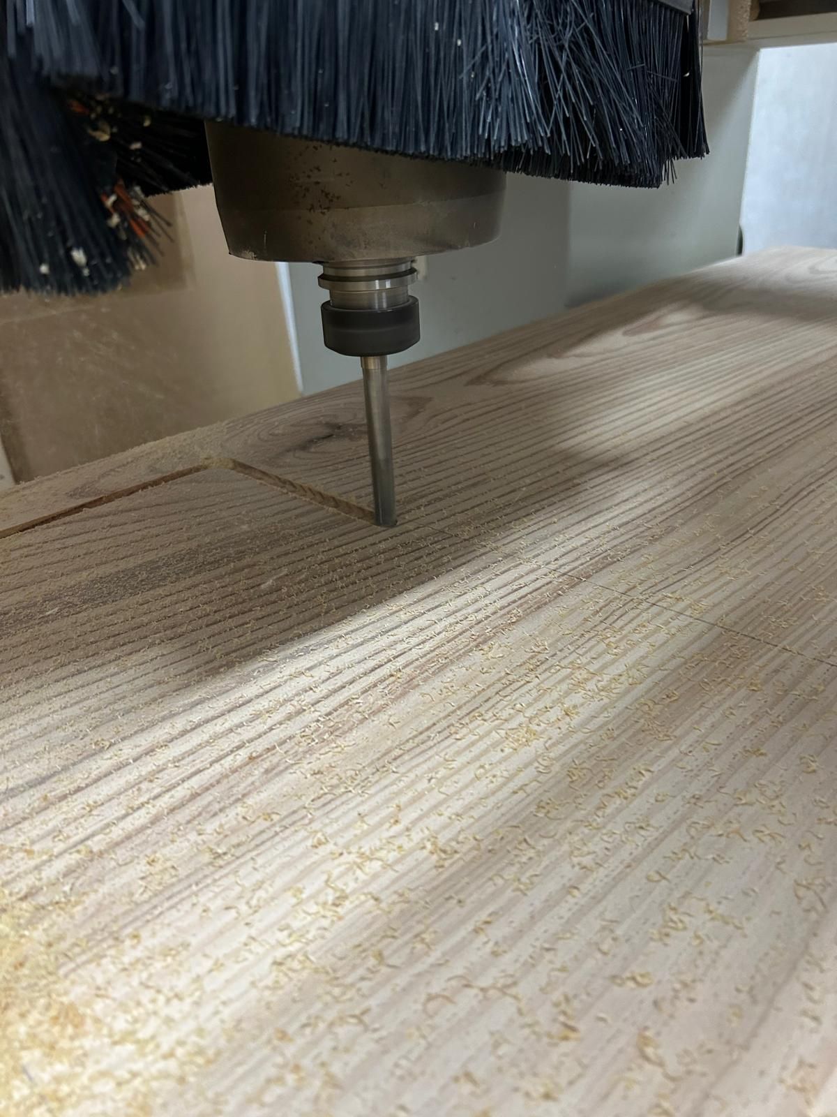 Intaglio a mandrino CNC di una superficie in legno con una fine venatura parallela
