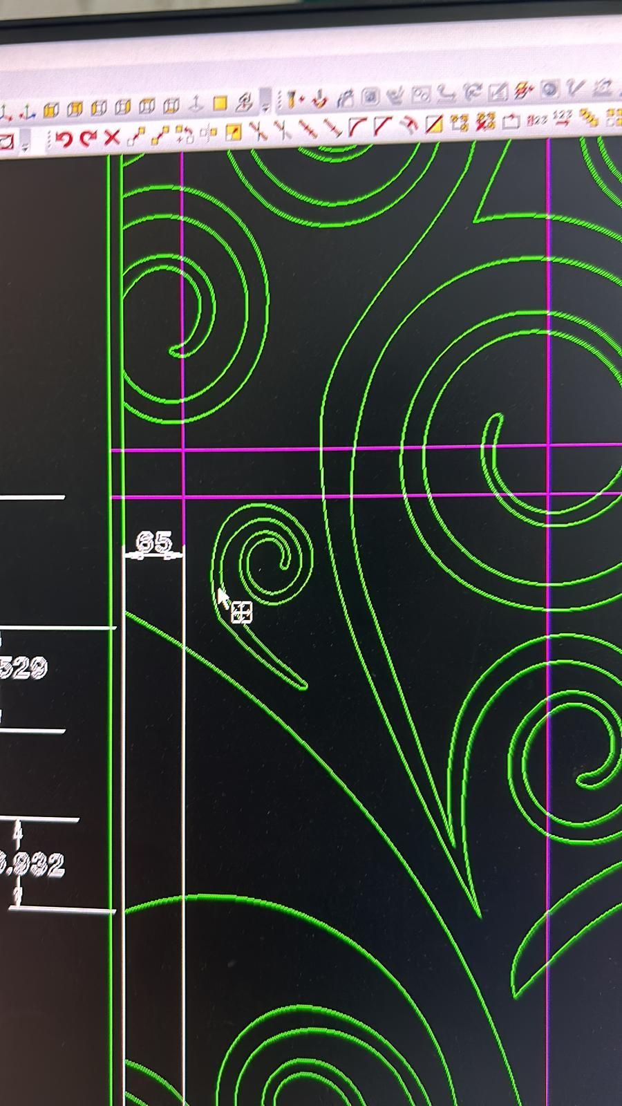 Motivo ornamentale curvilineo verde in stile CAD su sfondo nero con linee di allineamento magenta e barre degli strumenti in alto