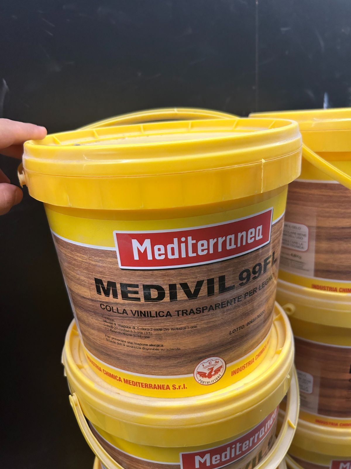 Secchi di vernice gialla impilati su uno scaffale con l'etichetta