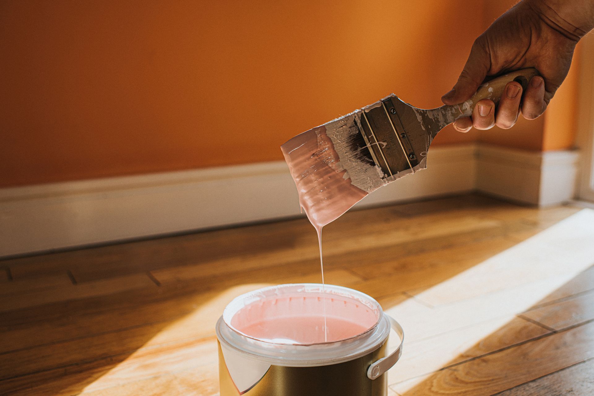 A person is pouring pink paint into a bucket. A person is pouring pink paint into a bucket.