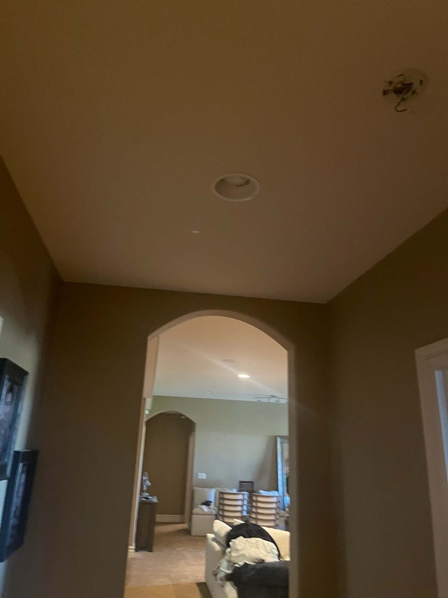 A hallway leading to a living room with a ceiling light.