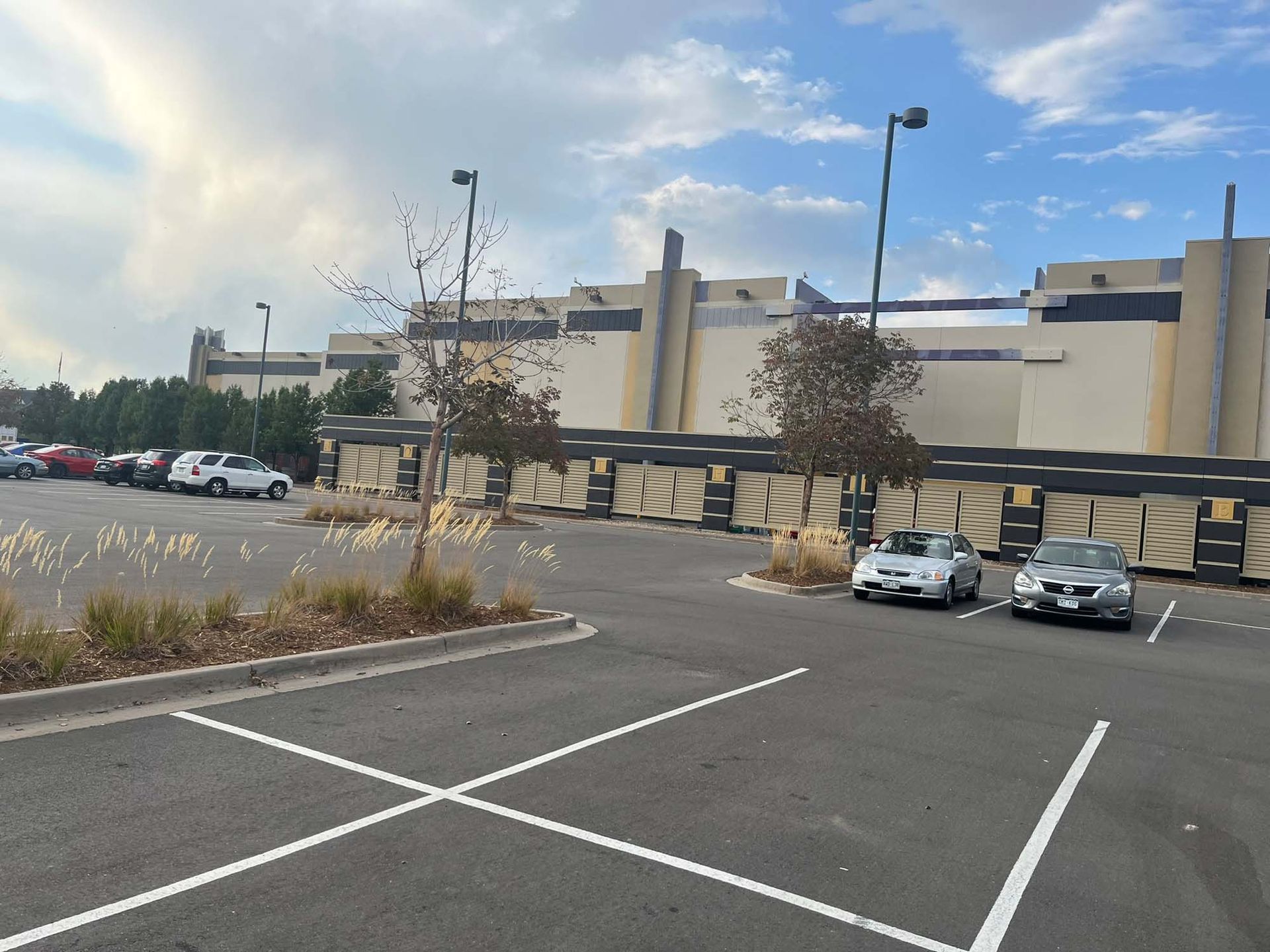A parking lot with cars parked in front of a building