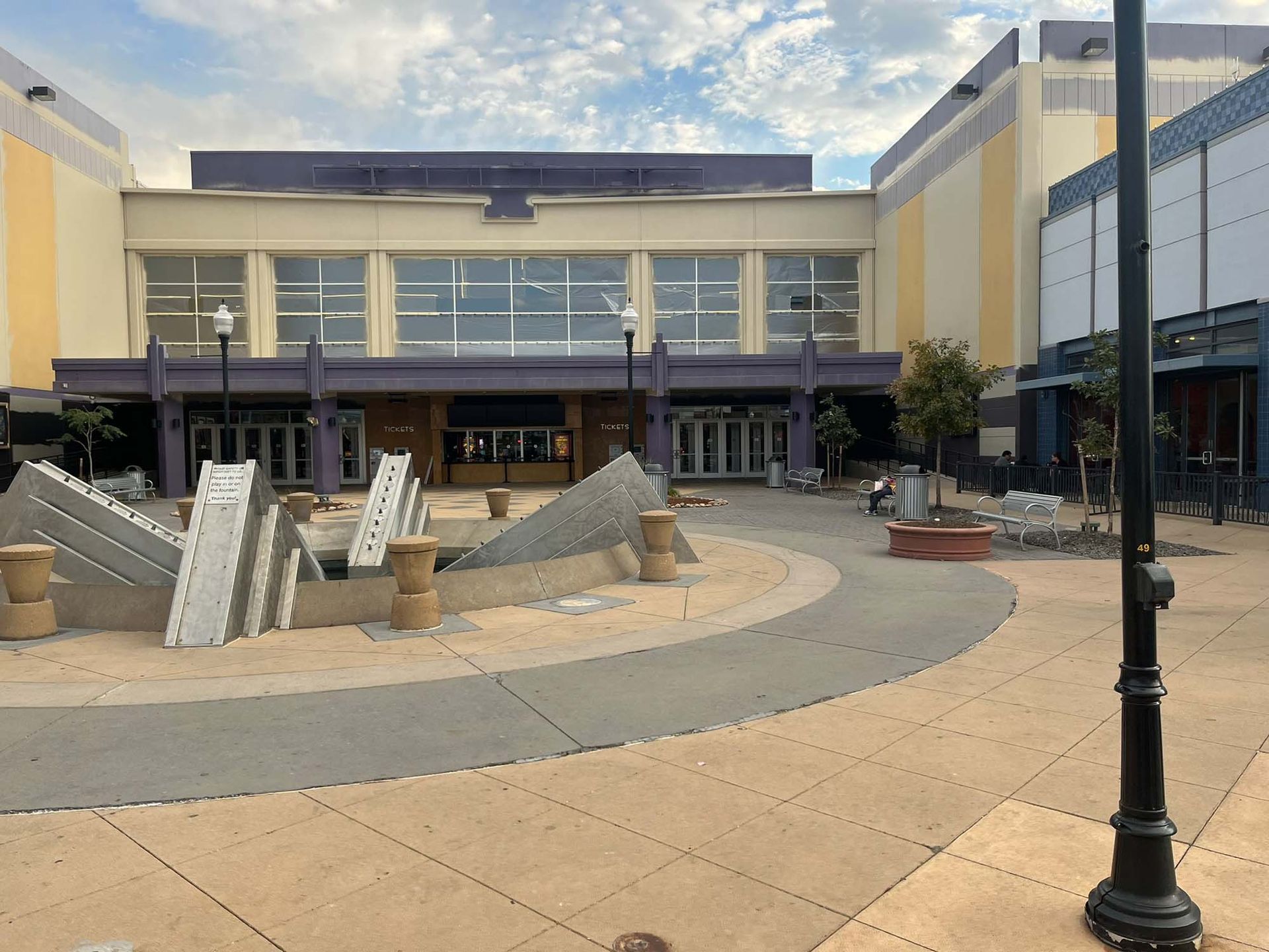 A large building with a purple roof is surrounded by a courtyard
