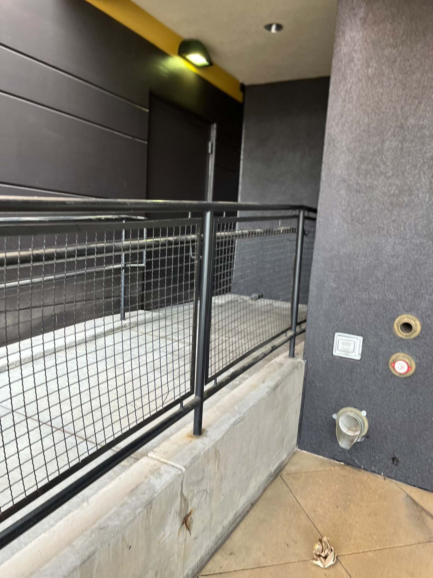 A building with a fence and a ramp leading to it