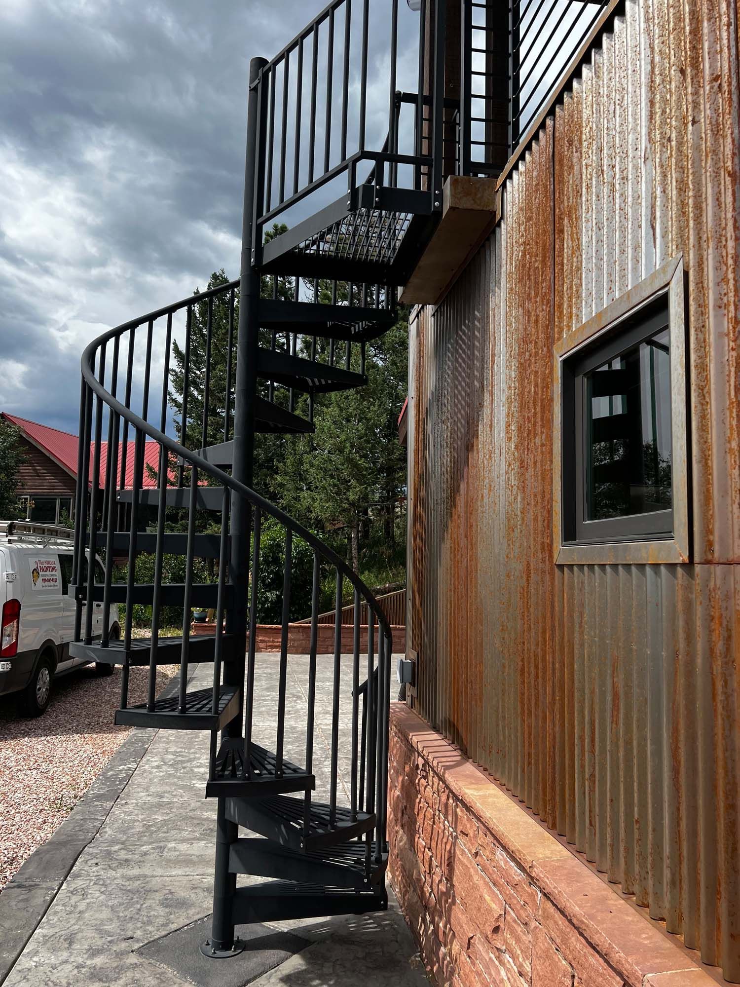 A spiral staircase is attached to the side of a building.