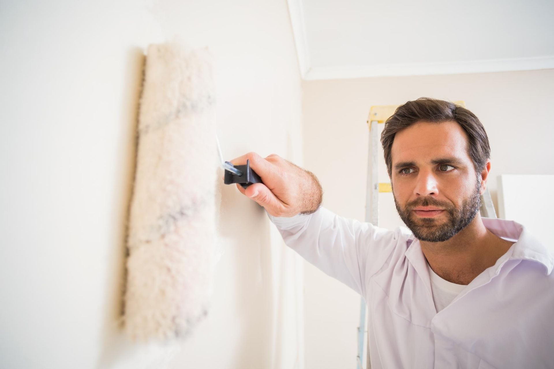 a man in a white shirt is writing on a wall