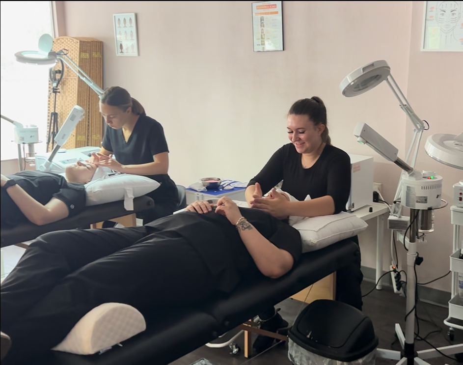 Beautician applying facial mask to a client in a spa setting.