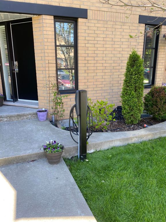 Une maison en brique avec une passerelle en béton menant à la porte d'entrée.