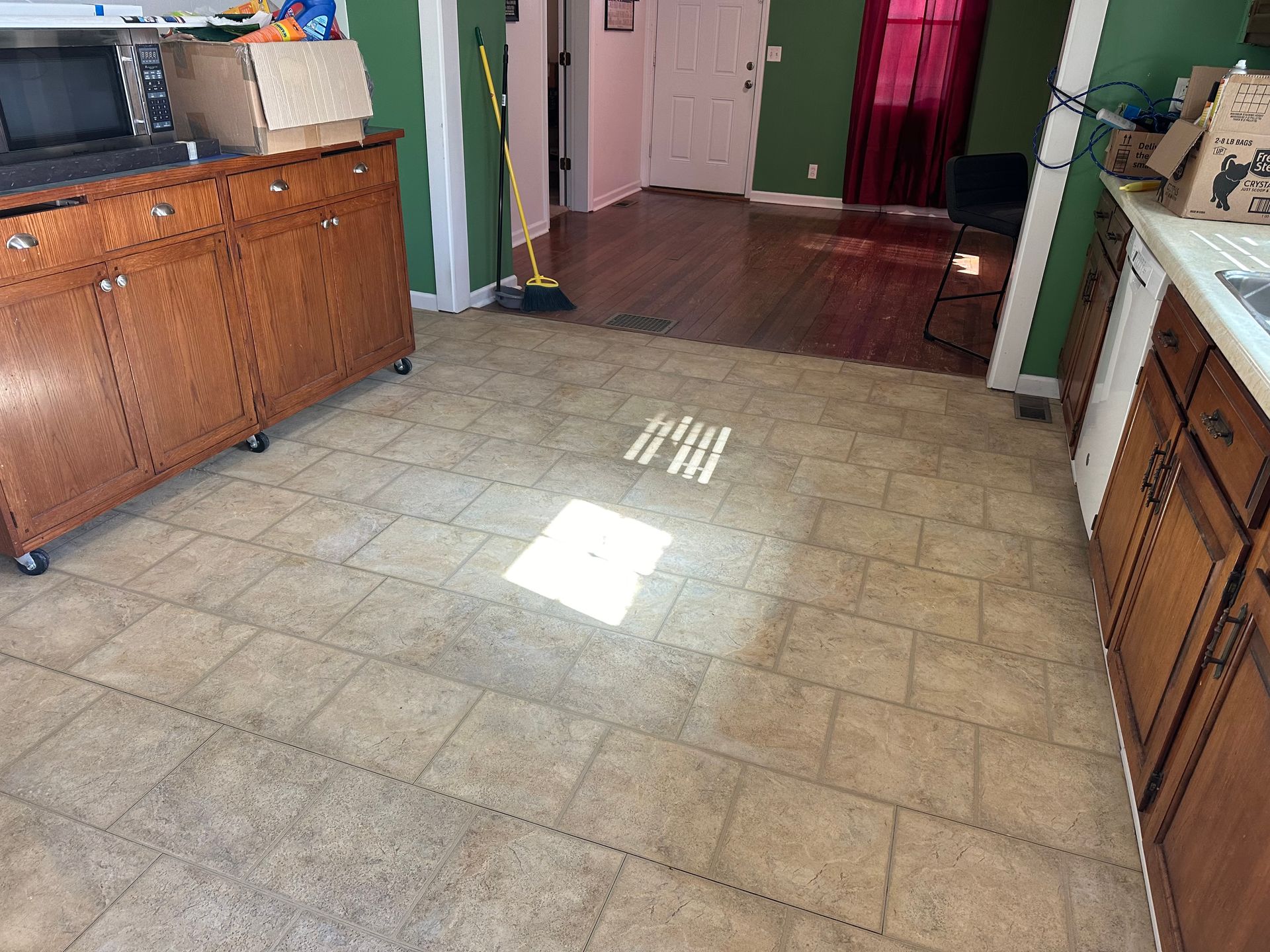 A kitchen with a tile floor and wooden cabinets.