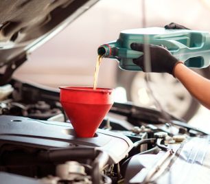 Oil being poured into hood of vehicle | Xpertech Auto Repair, Inc.