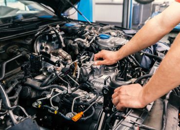 Technician looking under hood of vehicle | Xpertech Auto Repair, Inc.