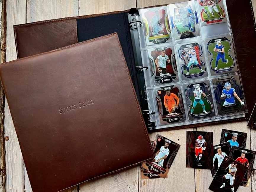 A binder filled with cards is sitting on a wooden table.
