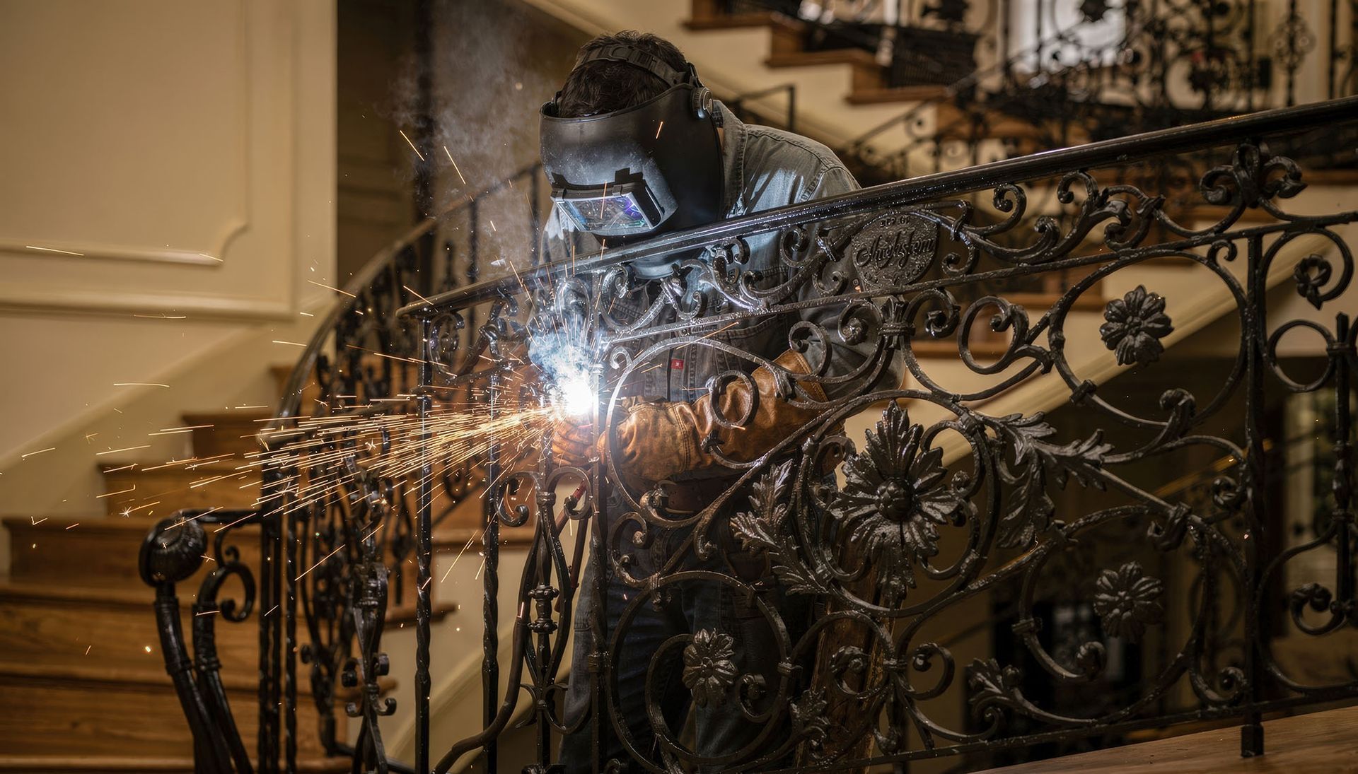 Crafting decorative wrought iron railings with custom scrollwork during fabrication. Crafting decorative wrought iron railings with custom scrollwork during fabrication.