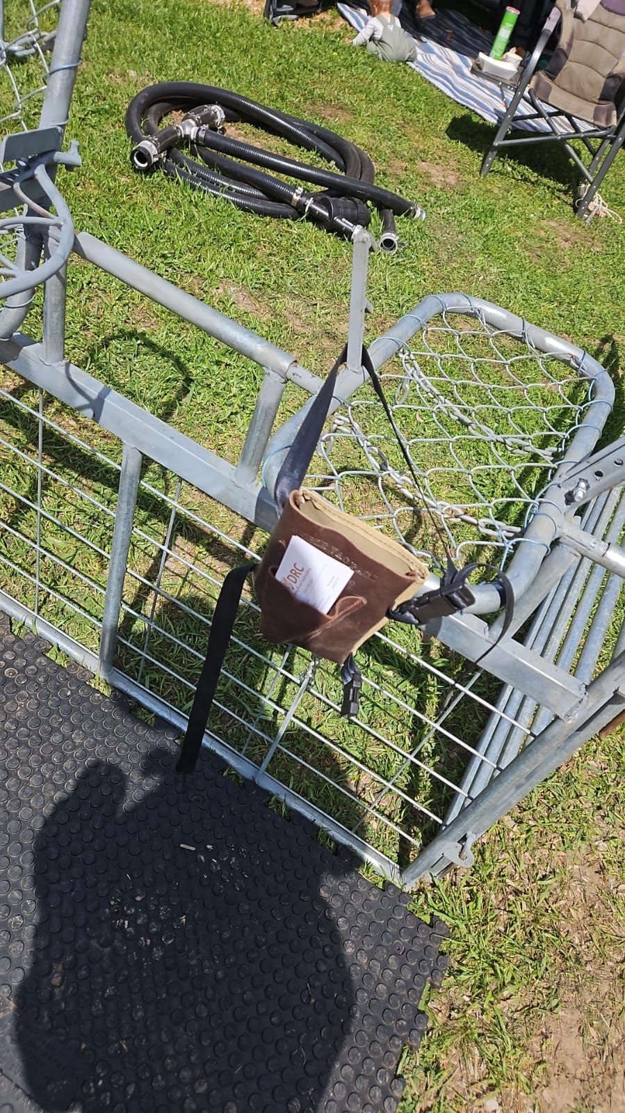 Gray bicycle carrier rack with a brown lock on grass beside a curb and sidewalk — Dusty Rural Contracting in Coolac, NSW