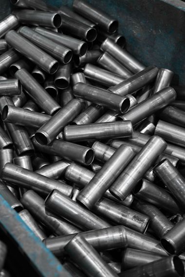 Un tas de boulons métalliques brillants éparpillés dans un conteneur