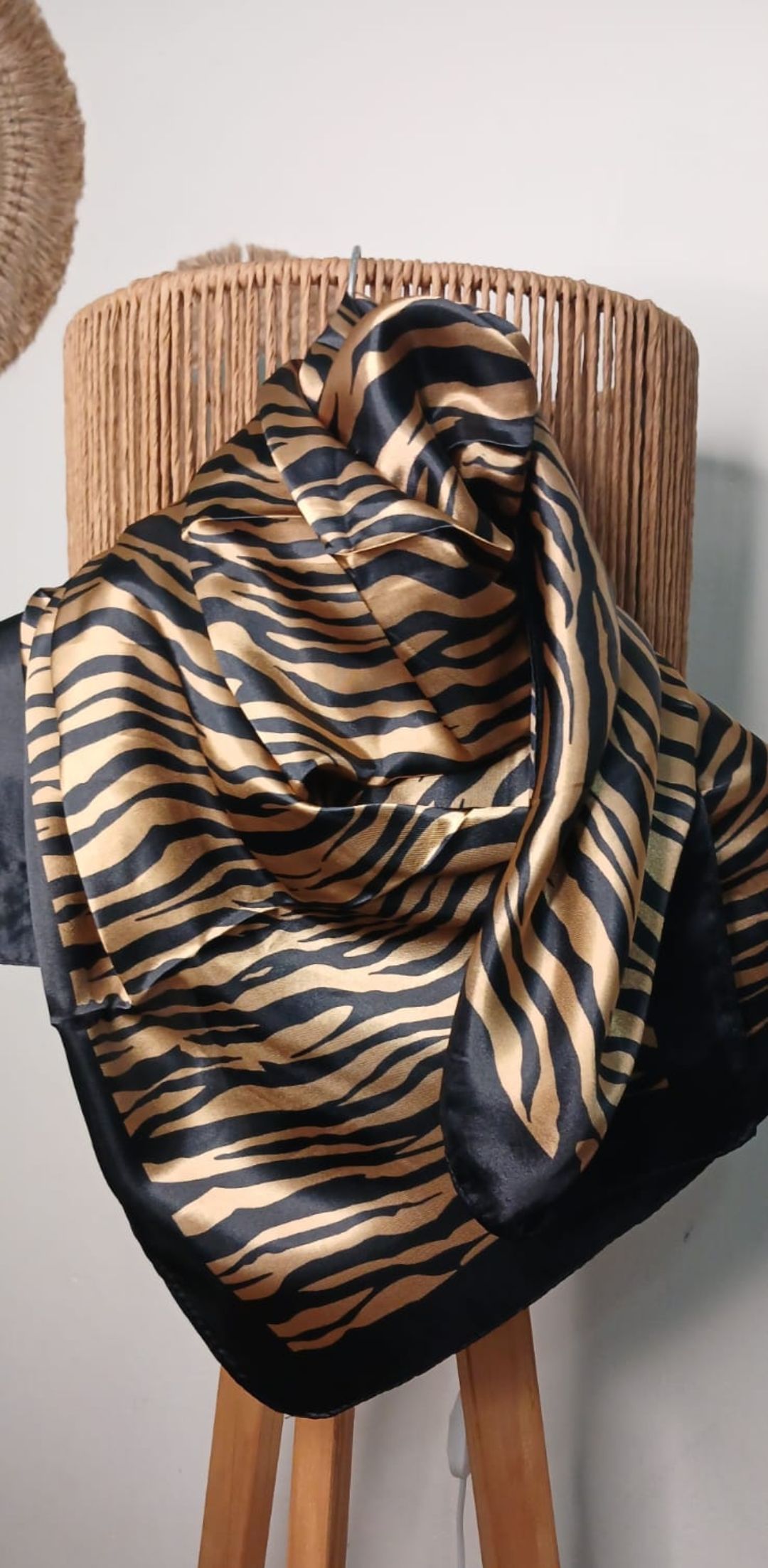 Bufanda con estampado de leopardo colocada sobre una silla de madera en una habitación.