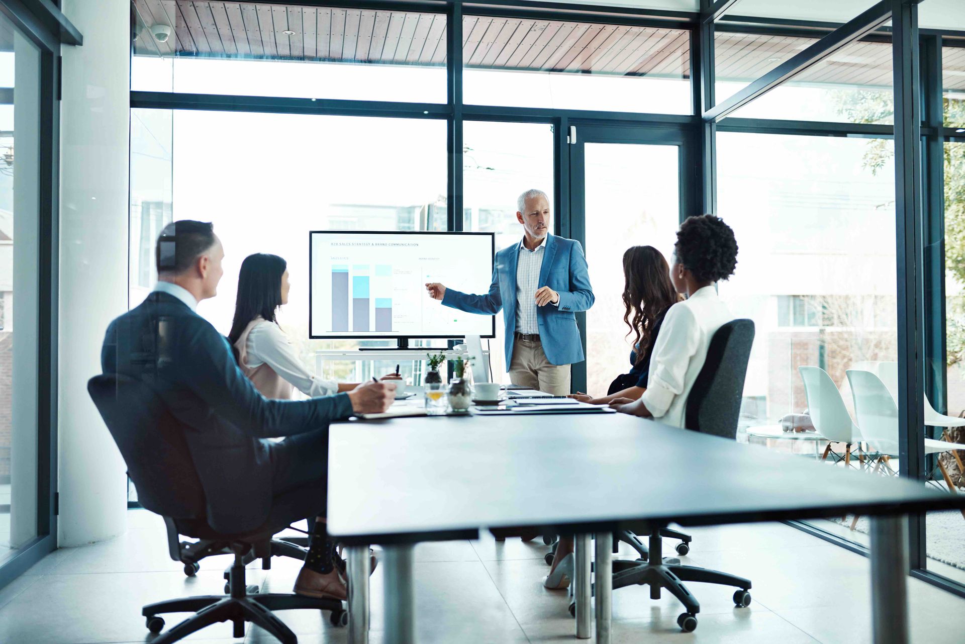 A man is giving a presentation to a group of people in a conference room.