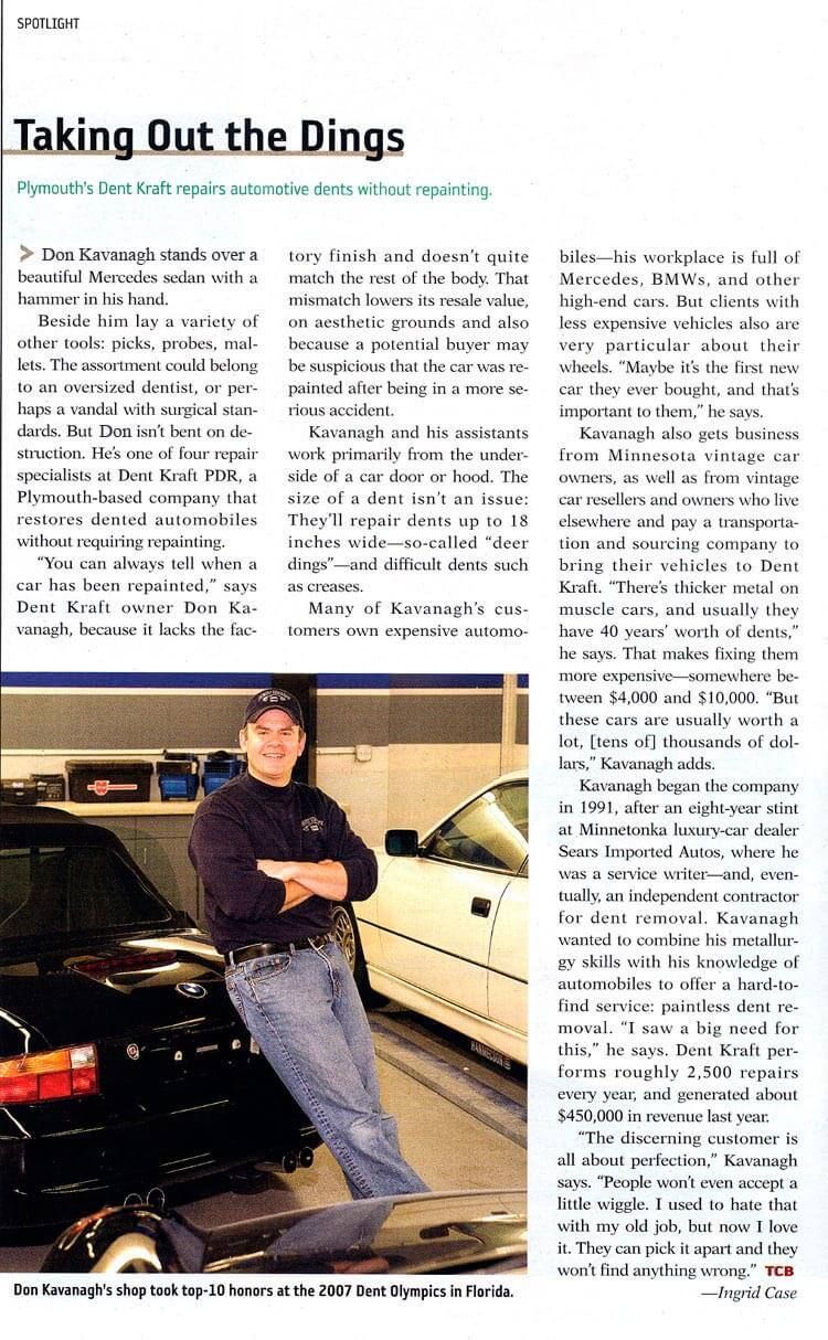 A man is standing next to a car in a garage.