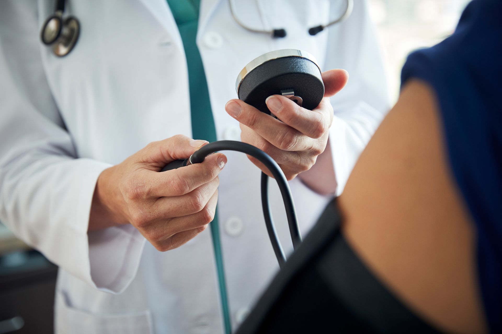 A doctor taking a patient's blood pressure during a commercial driver medical assessment.