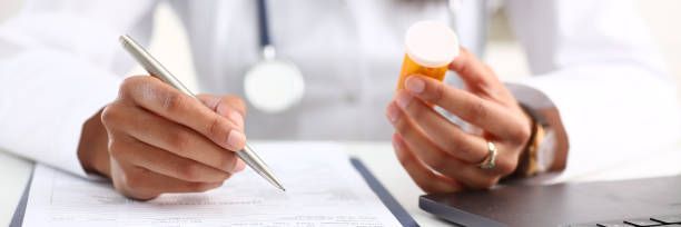Close-up of a doctor’s hand writing prescription, showcasing instant drug screening.