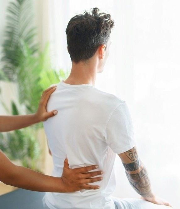 A Woman is Giving a Man a Massage in a Room — Life24 Health Bowen Therapy In Lavington, NSW