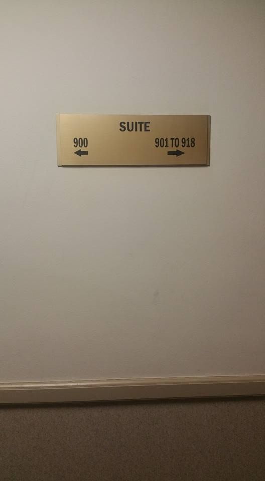 Hallway wall sign reading “SUITE” with room numbers 908–913 on a beige plaque