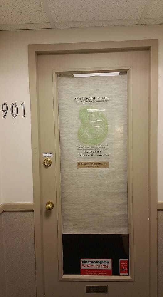 Apartment door with beige trim, frosted glass, and a green circular sign in a hallway next to room 901