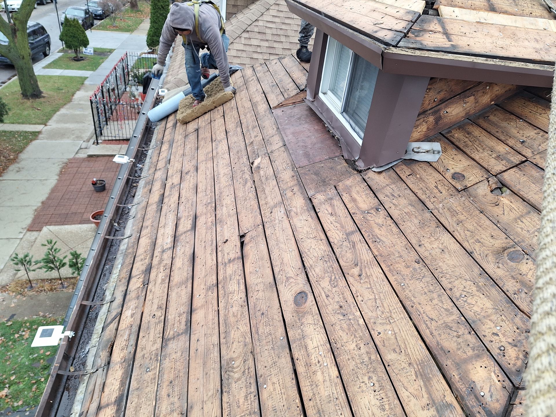 A man is working on the roof of a house.
