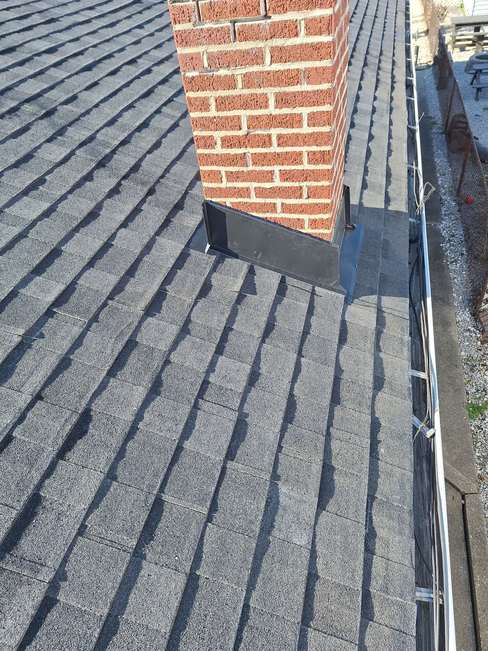 A close up of a roof with a chimney on it.