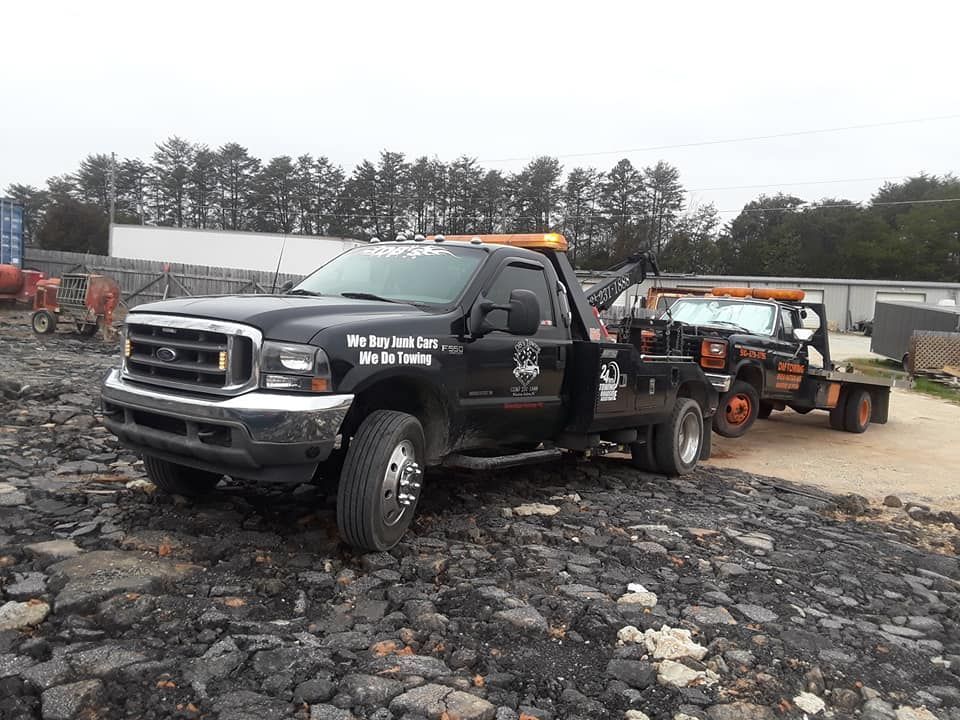 A black tow truck is sitting on top of a pile of rocks.