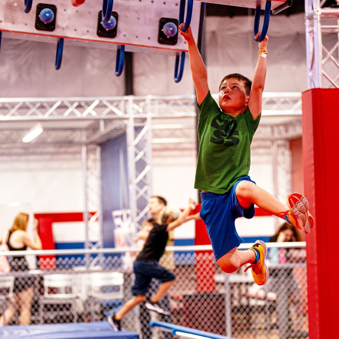 A kid swinging on the monkey bars at Ninja Nation ATX summer camp