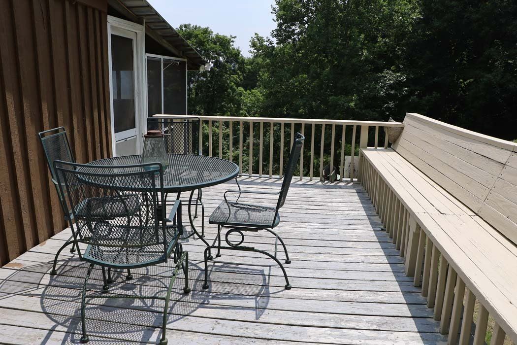 A deck with a table and chairs and a bench