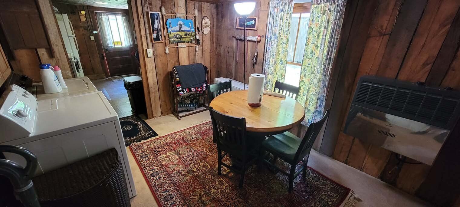 A kitchen with a table and chairs and a washer and dryer.