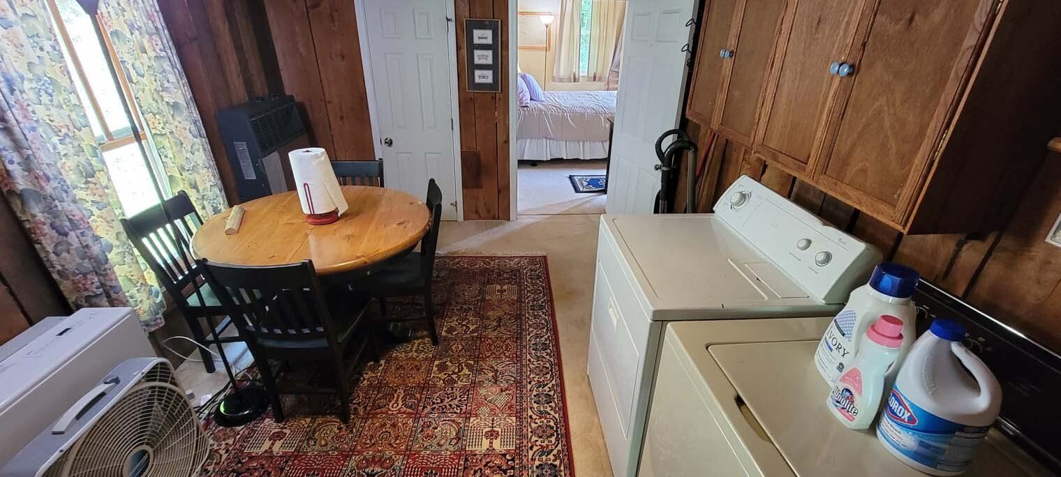 A laundry room with a table and chairs and a washer and dryer.