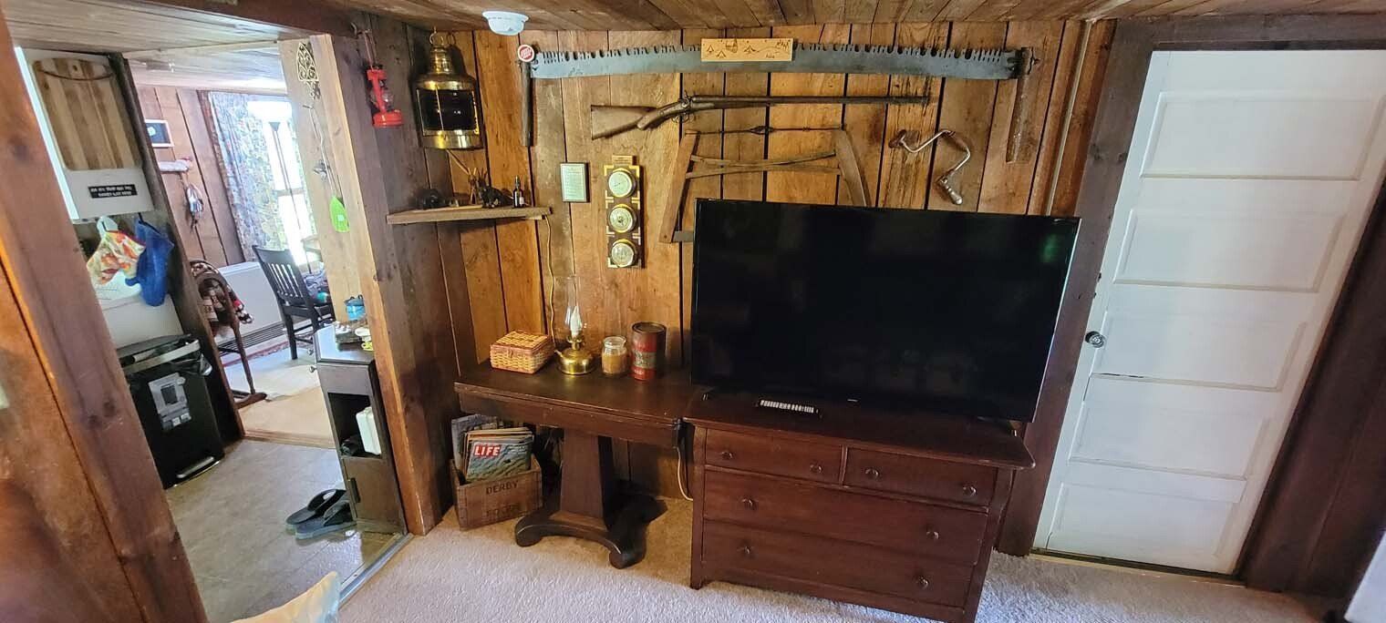 A living room with a flat screen tv on a wooden stand.