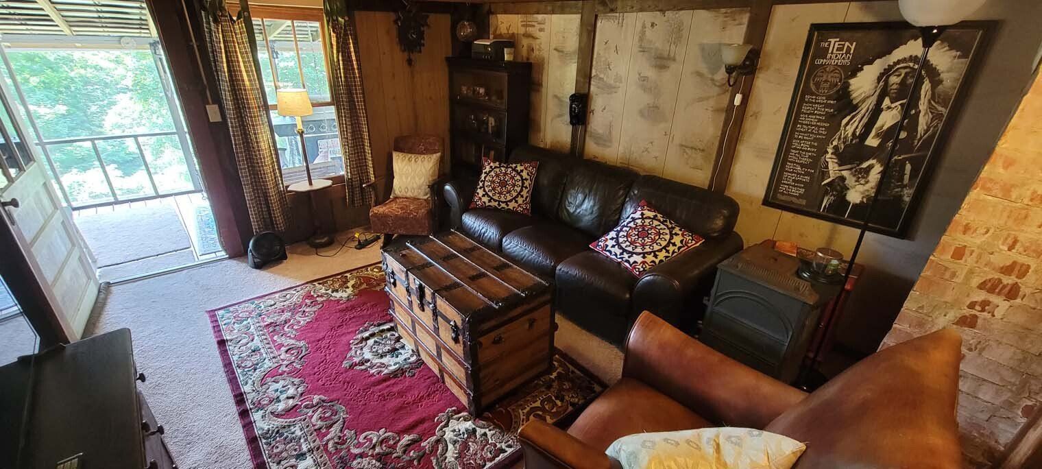 An aerial view of a living room with a couch , chair and trunk.