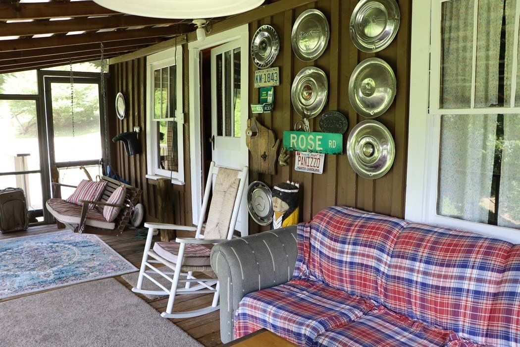 A living room with a couch , rocking chairs , and a sign that says `` rose ''.