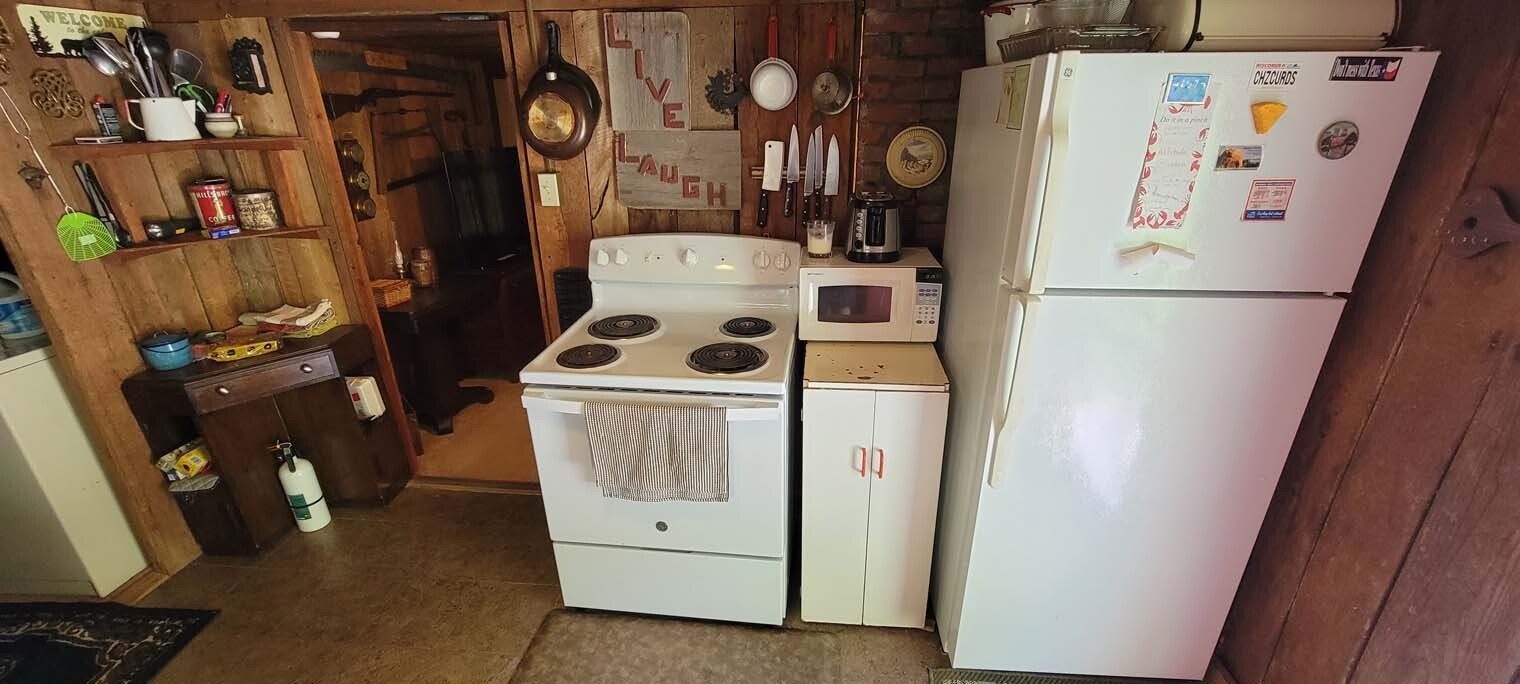 A kitchen with a stove , refrigerator , washer and dryer.