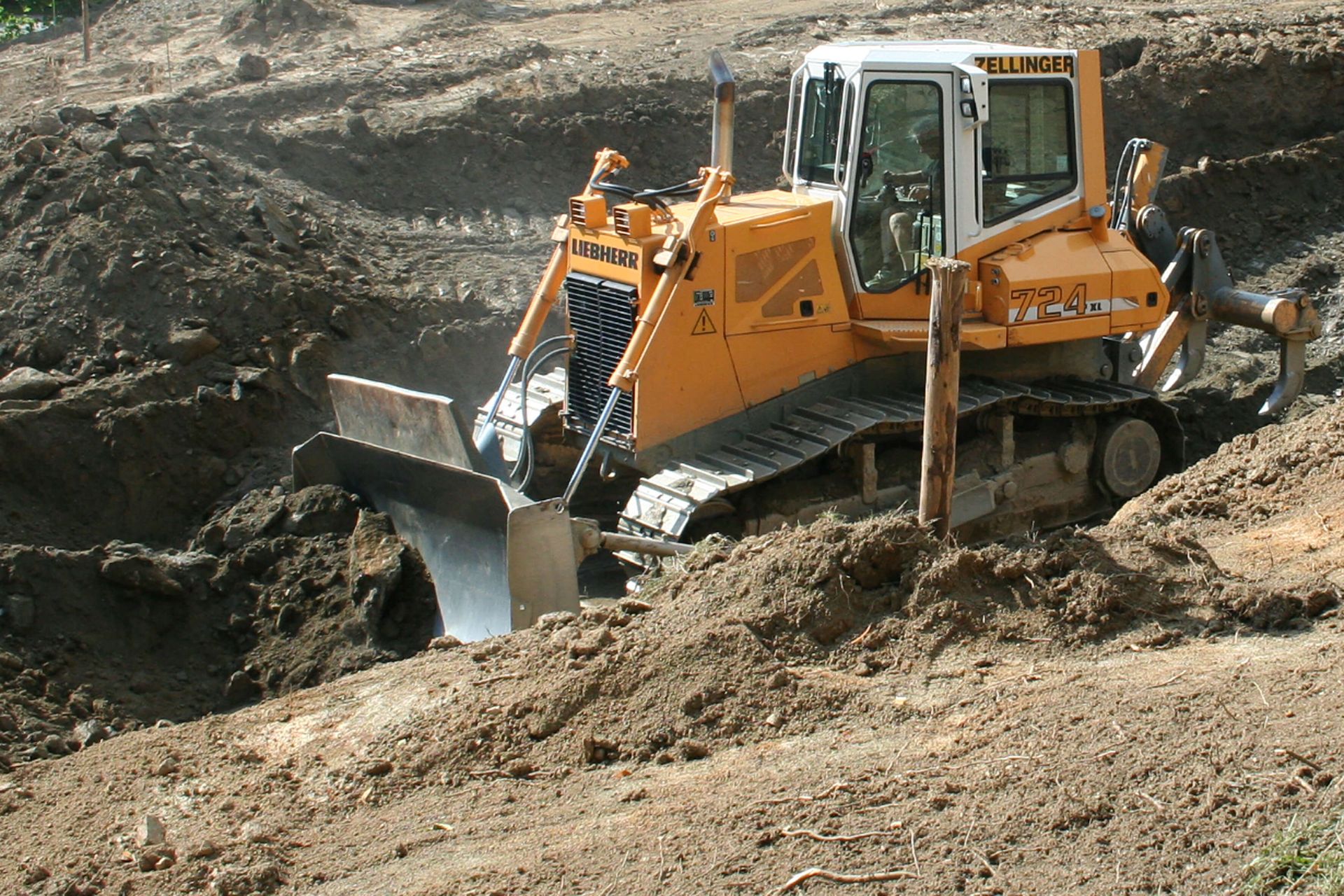 Yellow bulldozer pushing dirt on a construction site.