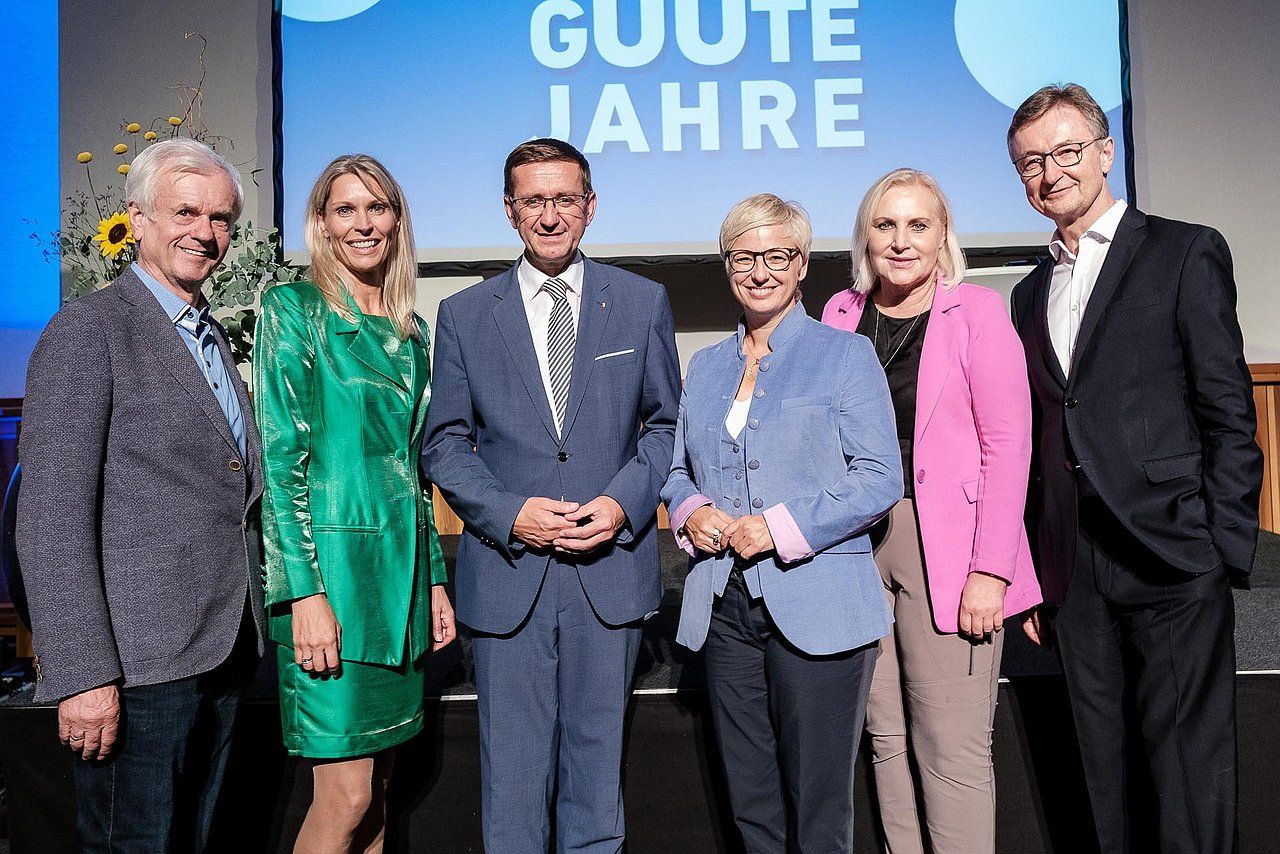 Group of six people smiling at an event with 