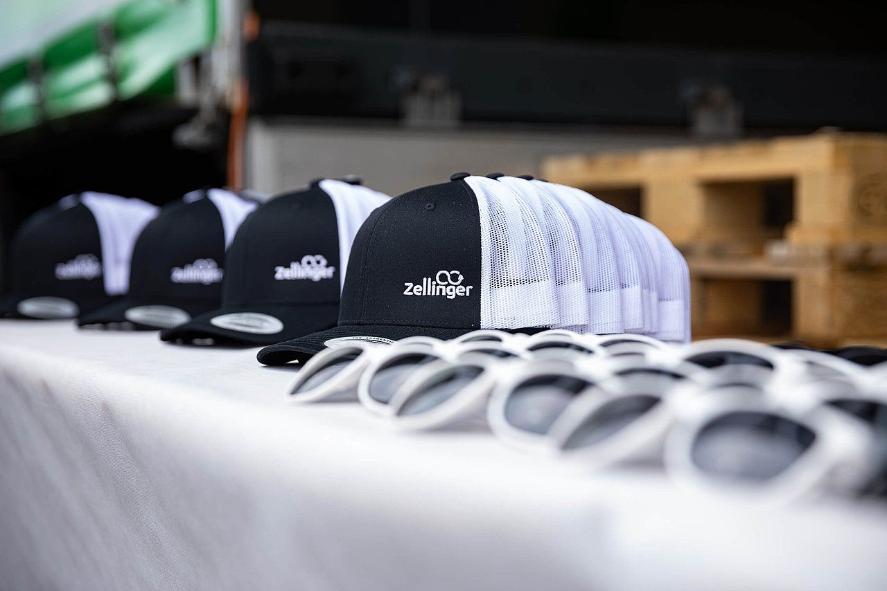 Black and white caps and sunglasses lined up on a table.