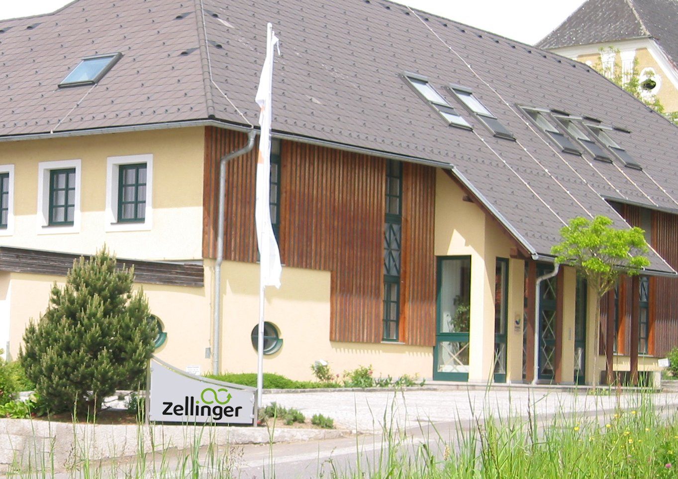 Building with brown wood siding, yellow walls, and a sign that says