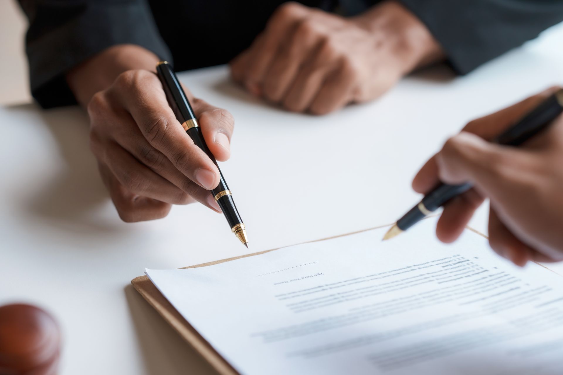 A couple sits across from a professional mediator at the table during a mediation services meeting. Conflict mediation service session with a neutral mediator and two participants.