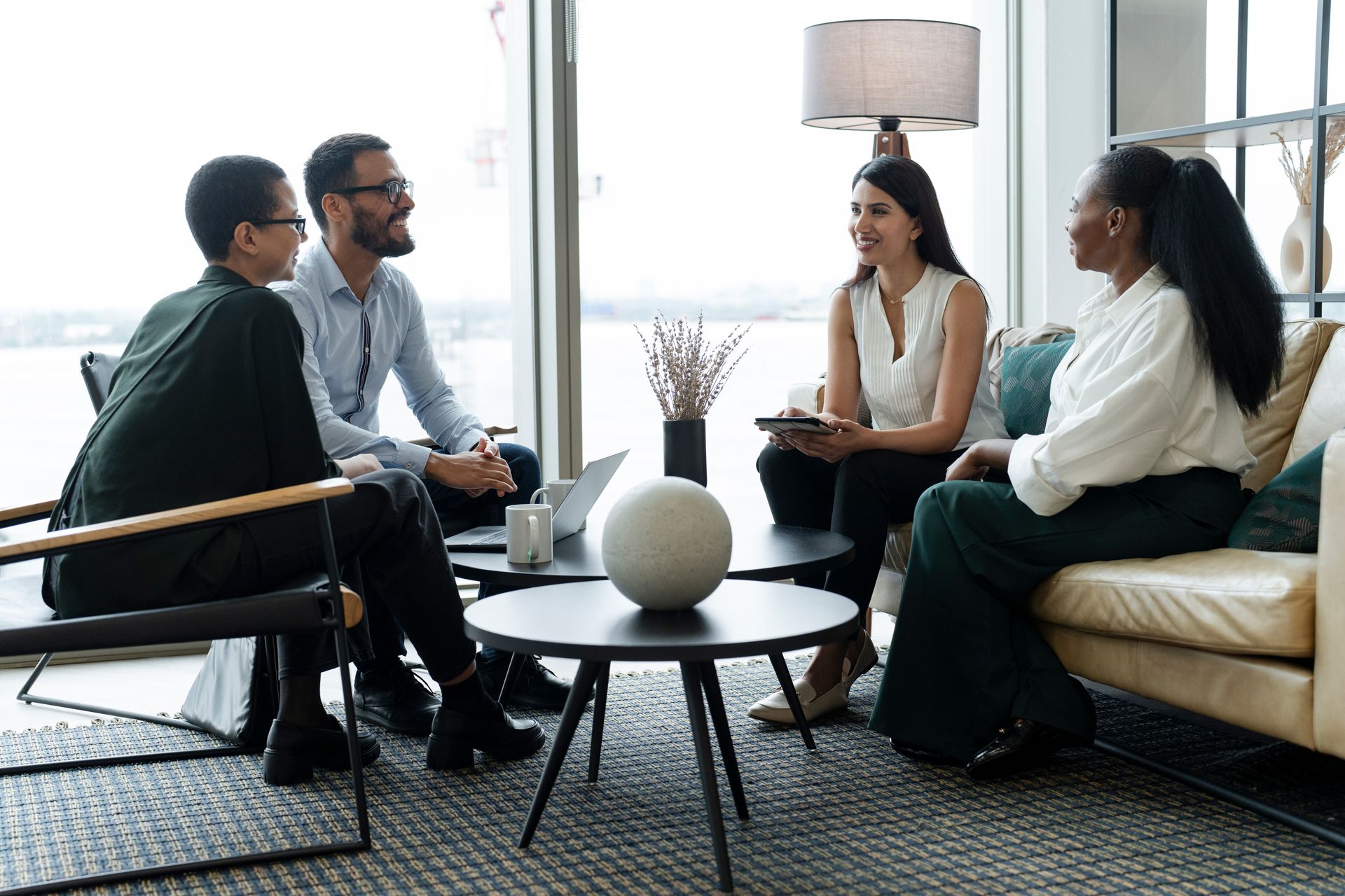 Four professionals discussing collaborative divorce in a bright office lounge