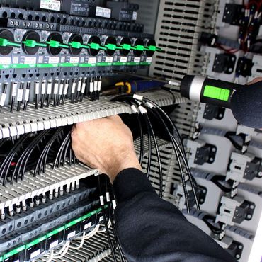 a man is working on an electrical panel with a screwdriver