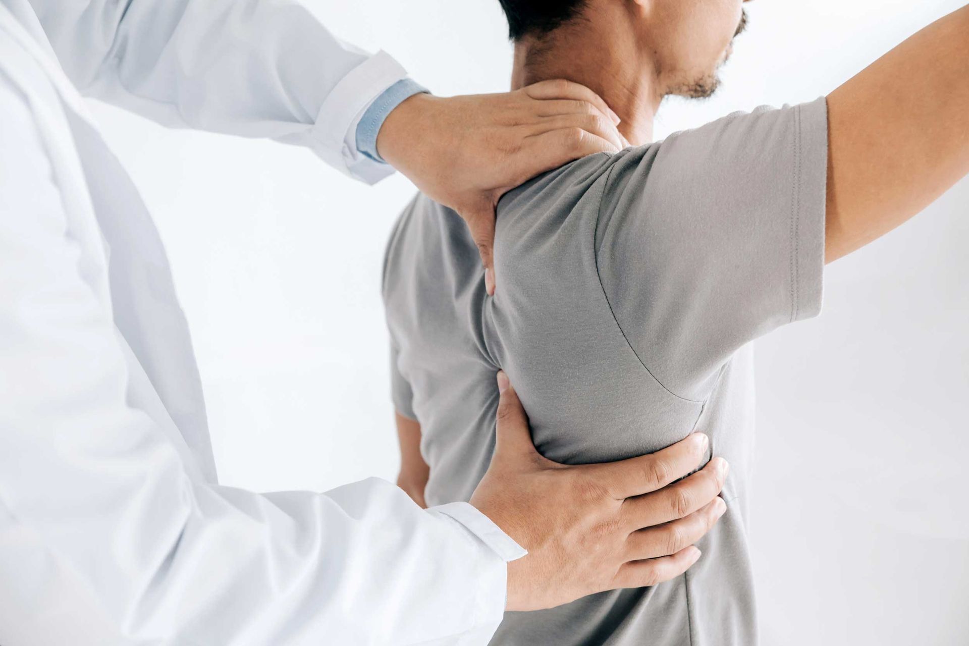 A physiotherapist is doing healing treatment on a man's back. A physiotherapist is doing healing treatment on a man's back.