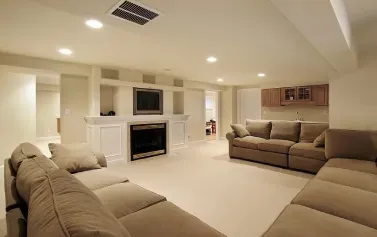 Spacious beige living room with sectional sofas, fireplace, TV, and recessed ceiling lights