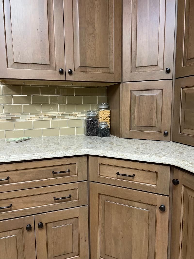 Wooden kitchen cabinets with granite countertop and beige tile backsplash
